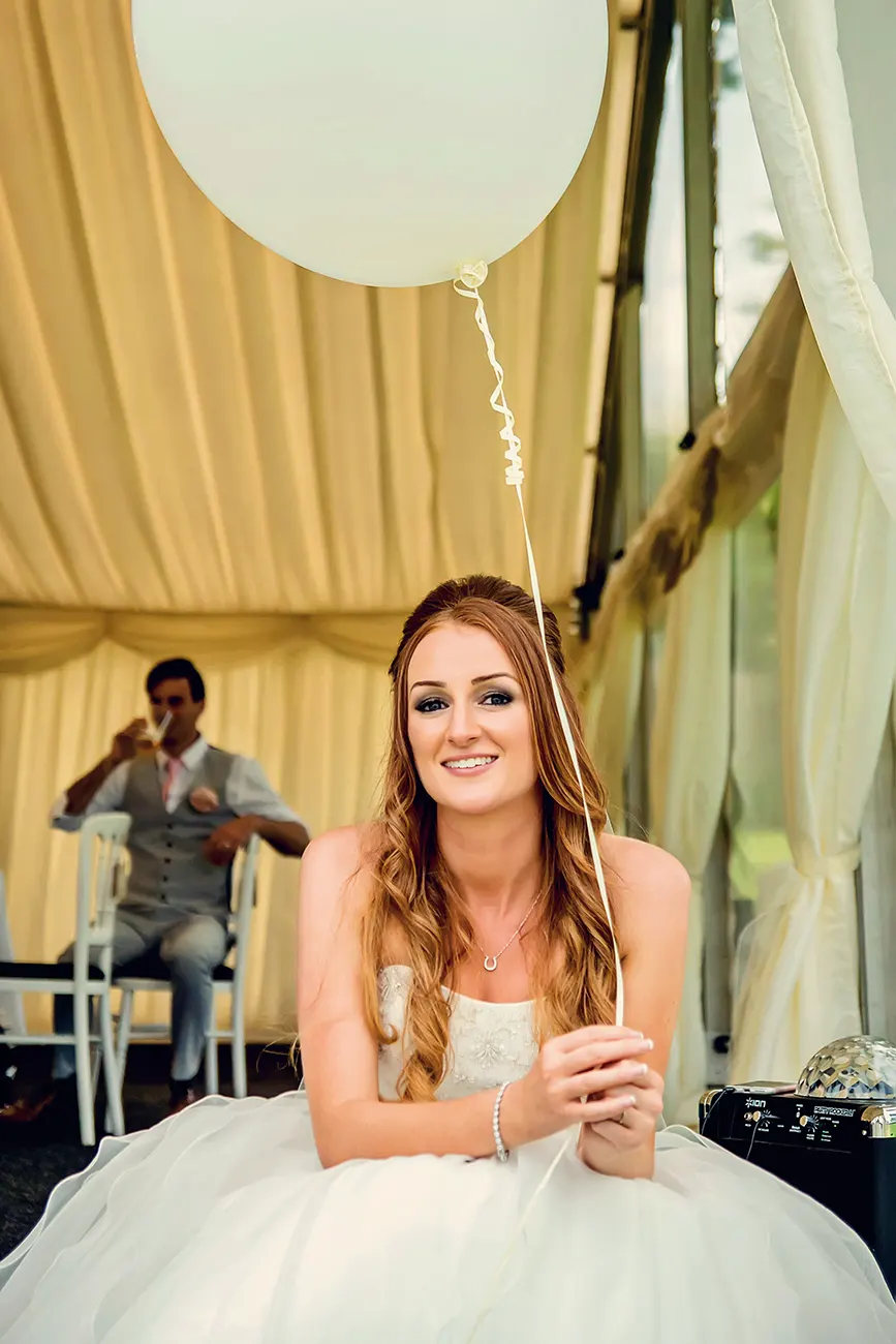 Bride sitting and holding a baloon after a micro wedding in Worcestershire