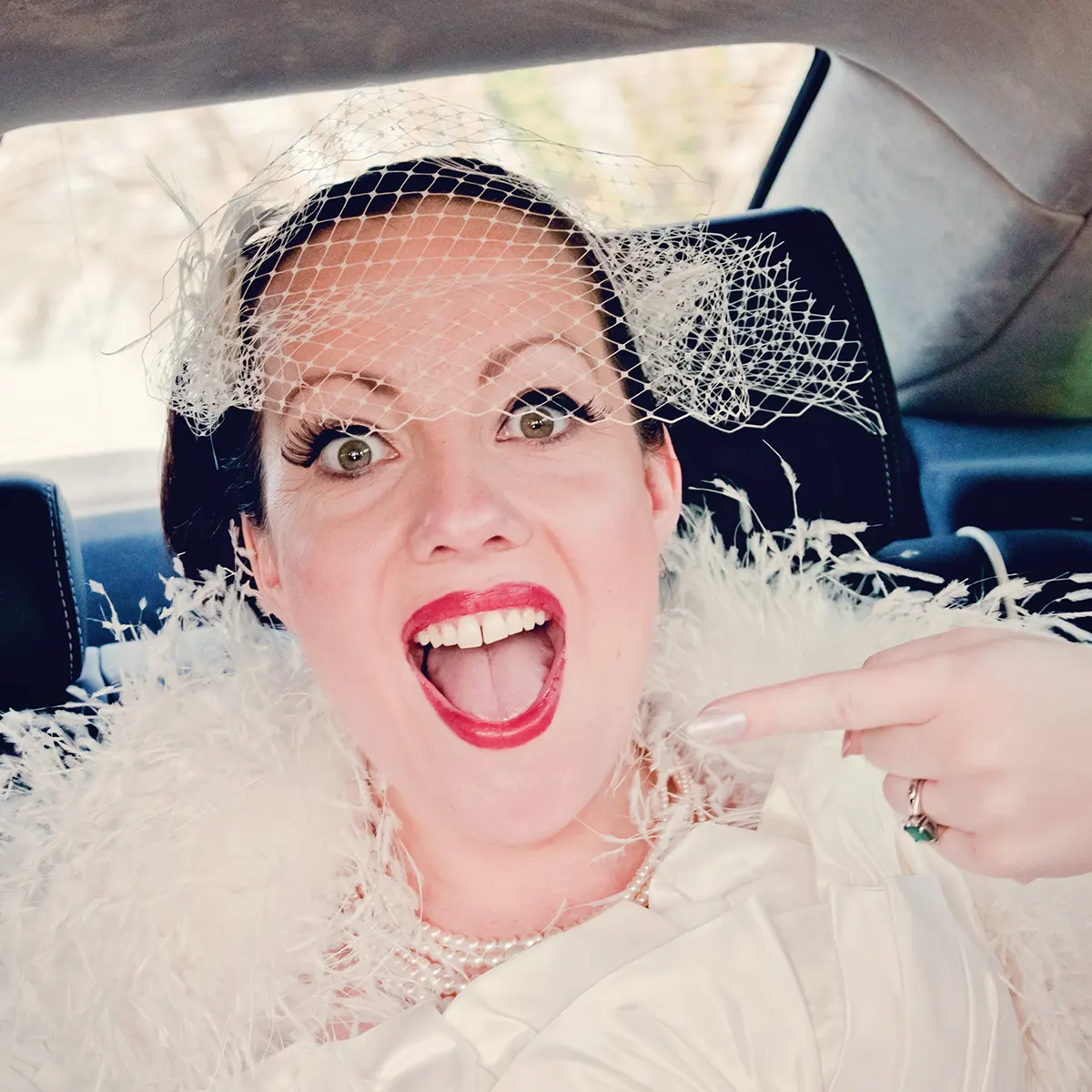 Bride pointing as she arrives to her wedding in Hagley